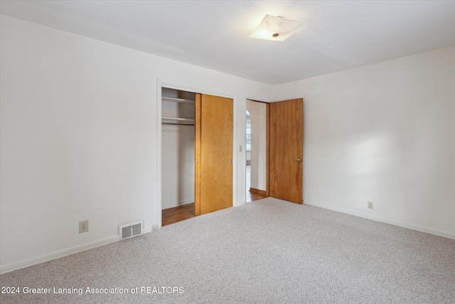 unfurnished bedroom with a closet and carpet floors