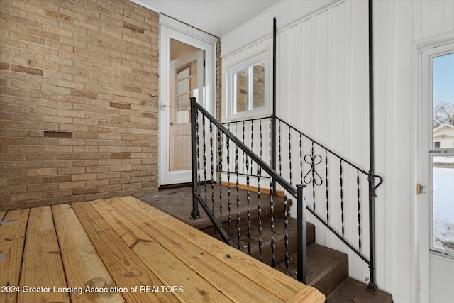 interior space featuring brick wall and wood-type flooring