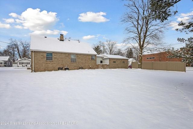 view of snow covered back of property