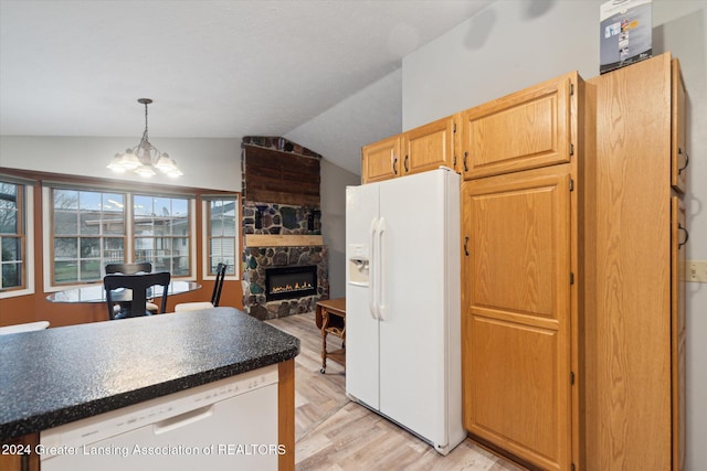 kitchen featuring white appliances, vaulted ceiling, light hardwood / wood-style flooring, a chandelier, and a fireplace