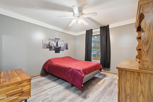 bedroom featuring a textured ceiling, ceiling fan, and light hardwood / wood-style floors