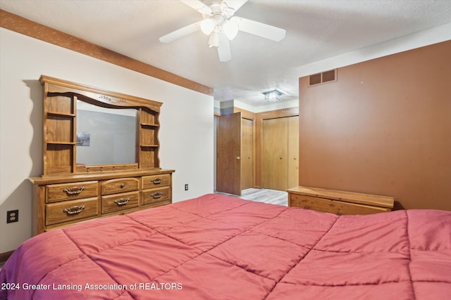 bedroom featuring a closet, ceiling fan, and a textured ceiling