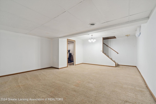 basement with a paneled ceiling and carpet flooring