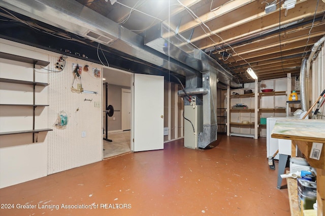 basement featuring heating unit, separate washer and dryer, and a workshop area