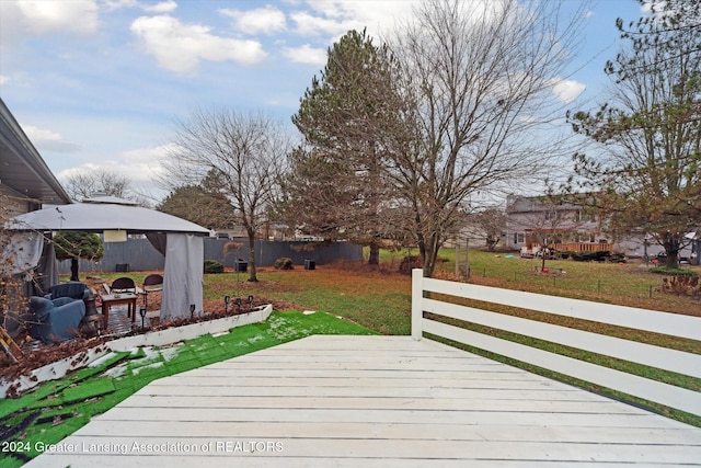 wooden deck with a lawn and a gazebo