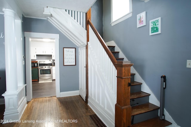 stairway featuring ornamental molding and hardwood / wood-style floors