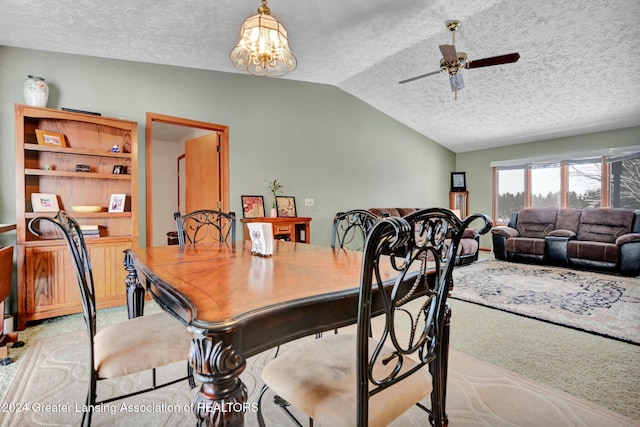 dining space featuring light carpet, a textured ceiling, ceiling fan with notable chandelier, and vaulted ceiling