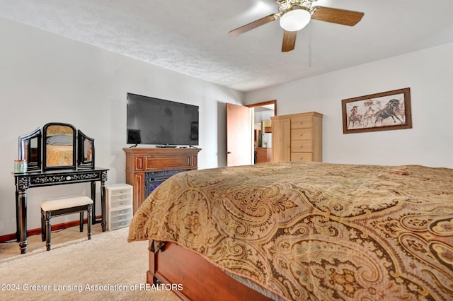 bedroom featuring carpet, a textured ceiling, and ceiling fan