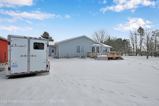 snow covered property with a deck