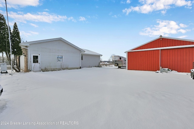 view of snow covered exterior with an outdoor structure