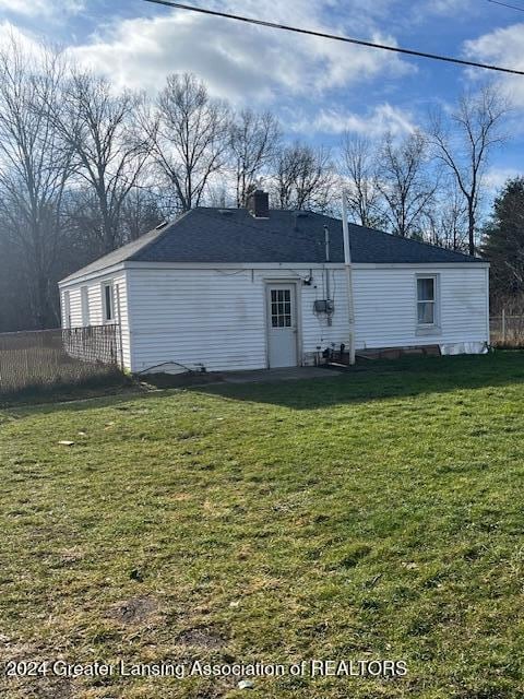 rear view of house featuring a lawn