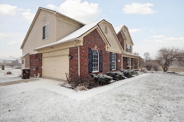 view of snow covered exterior with a garage