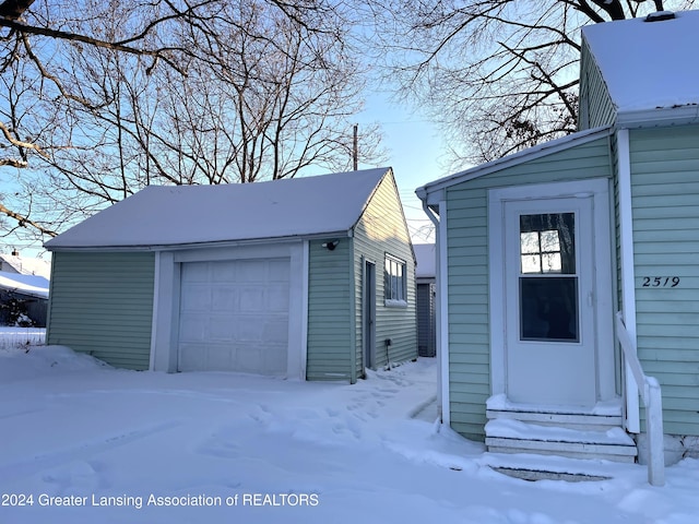 exterior space with a garage and an outbuilding