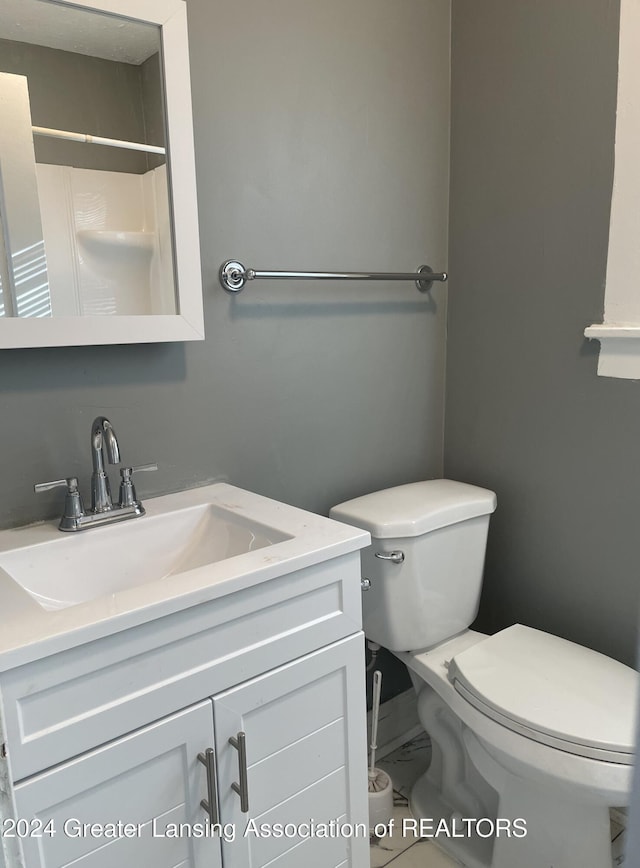 bathroom featuring walk in shower, vanity, and toilet