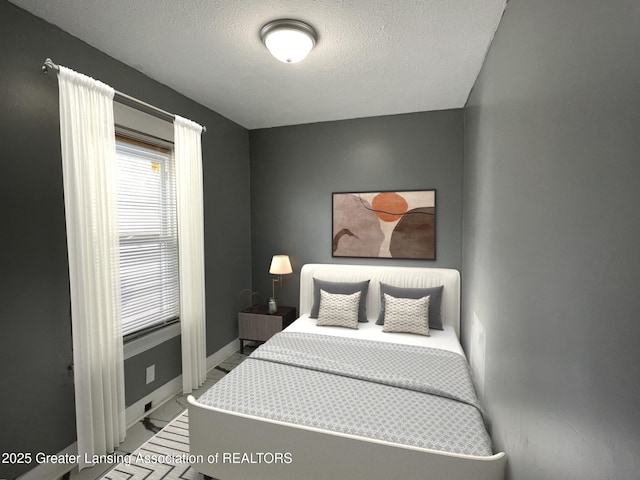 2519 S Washington Ave, Lansing, MI 48910 - bedroom with marble look tiles, baseboards, and a textured ceiling