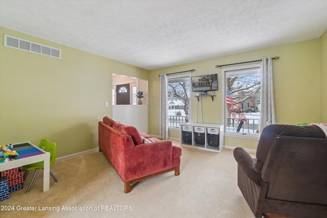 living room featuring light carpet, plenty of natural light, and a textured ceiling