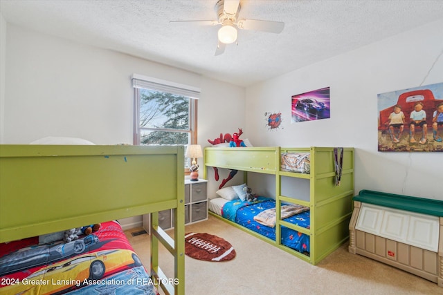 bedroom featuring ceiling fan, a textured ceiling, and light carpet