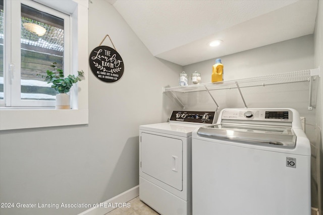 washroom featuring light tile patterned floors, a textured ceiling, and washer and clothes dryer