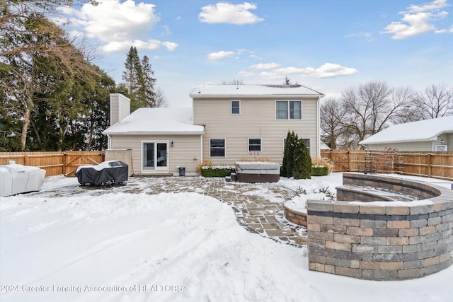 snow covered property featuring a jacuzzi