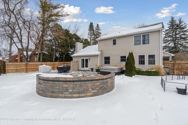 view of snow covered rear of property