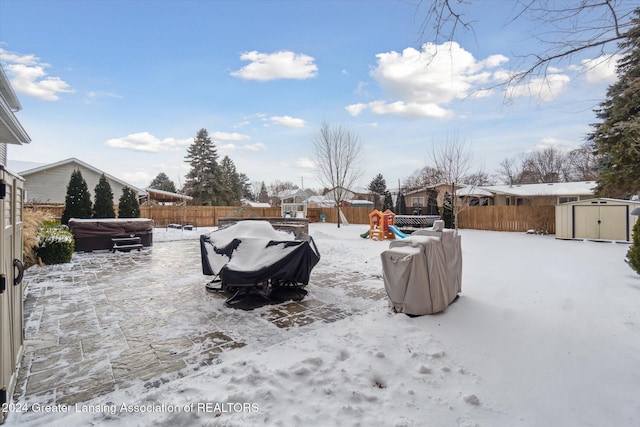 yard covered in snow with a playground and a storage shed