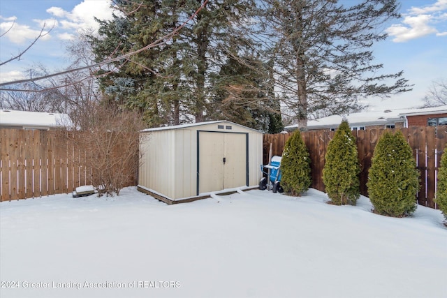 yard layered in snow with a storage unit