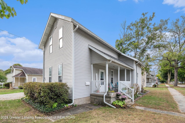 view of front of house with a porch and a front yard