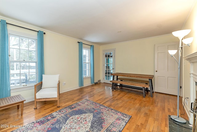 sitting room with wood-type flooring and ornamental molding