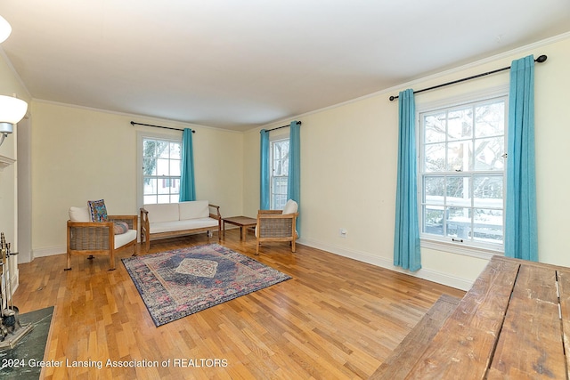 living area featuring crown molding and light wood-type flooring