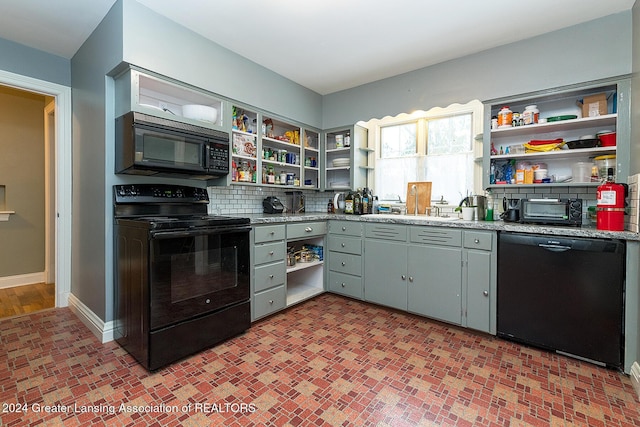 kitchen with black appliances, decorative backsplash, sink, and gray cabinetry