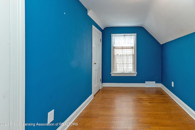 bonus room with lofted ceiling and hardwood / wood-style floors