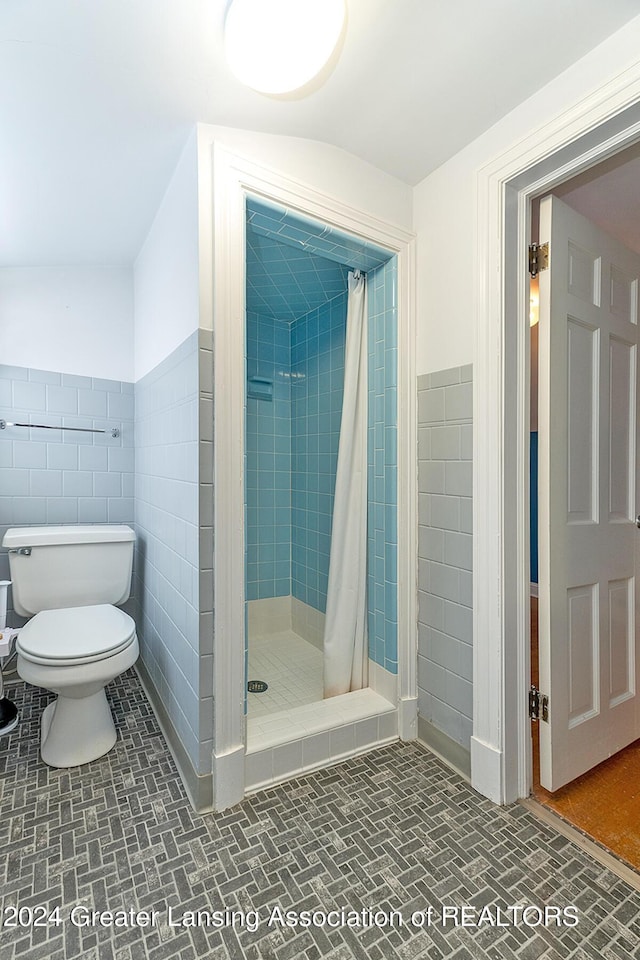 bathroom featuring curtained shower, tile walls, and toilet