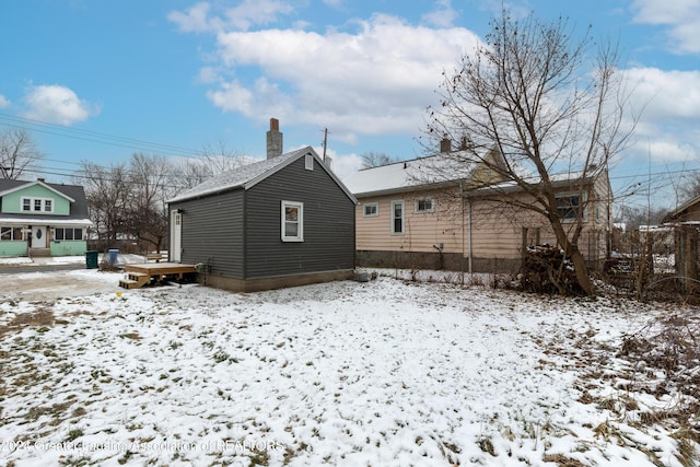 view of snow covered back of property