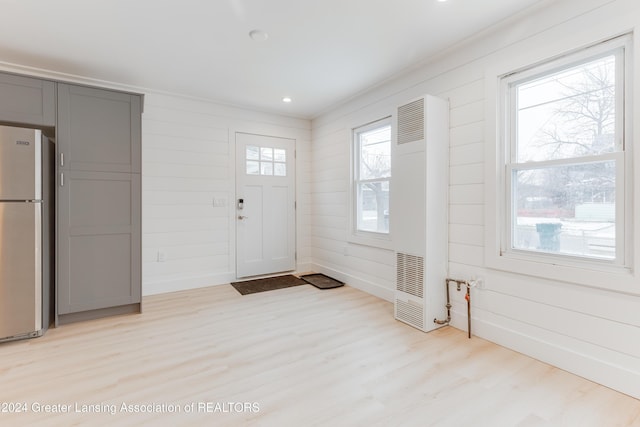 foyer featuring wooden walls and light hardwood / wood-style flooring