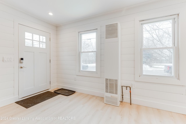 entryway featuring wood walls and light wood-type flooring