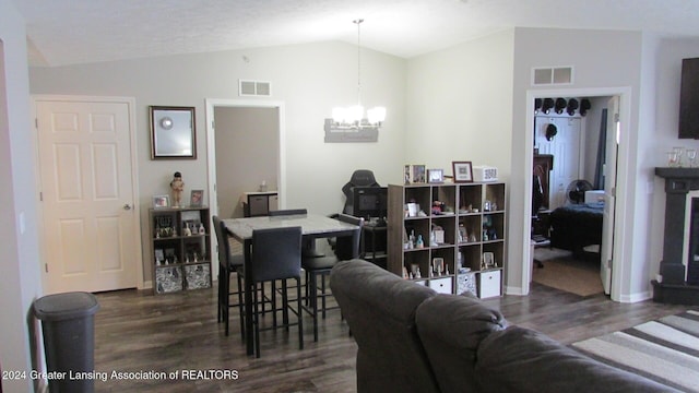 dining room with dark hardwood / wood-style flooring, lofted ceiling, and a chandelier