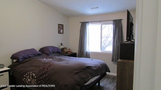 bedroom with lofted ceiling and hardwood / wood-style flooring