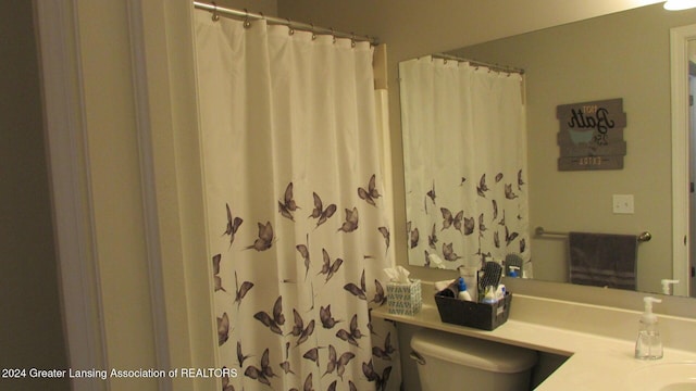 bathroom featuring a shower with curtain, vanity, and toilet