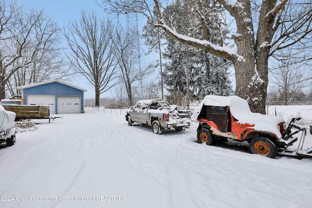 yard covered in snow with an outbuilding and a garage