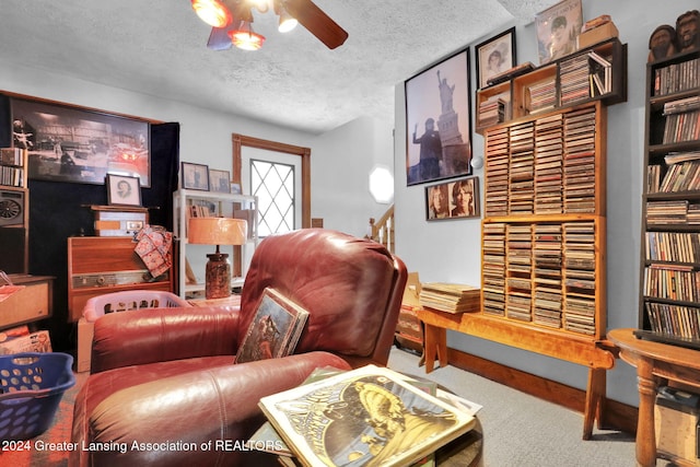 carpeted living room with a textured ceiling and ceiling fan