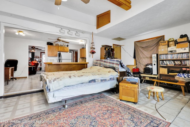 bedroom with ceiling fan and refrigerator