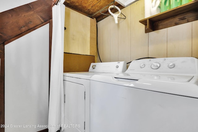 laundry room featuring washer and dryer, wooden walls, and wooden ceiling