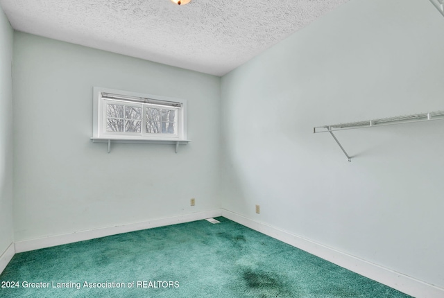 unfurnished room with a textured ceiling and carpet