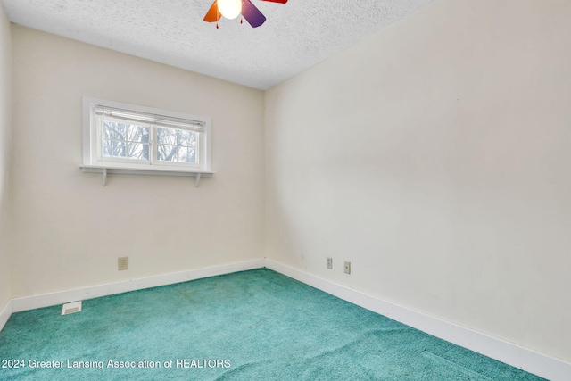 empty room featuring a textured ceiling, ceiling fan, and carpet