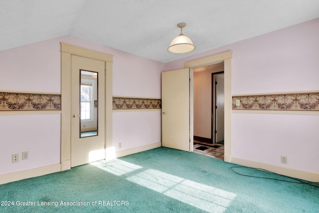 carpeted spare room with lofted ceiling