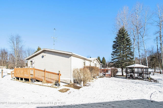 view of snow covered exterior featuring a gazebo and a deck