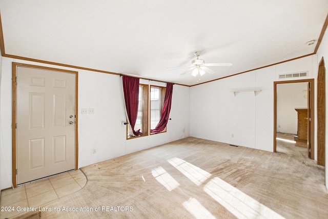 foyer featuring crown molding, lofted ceiling, light colored carpet, and ceiling fan