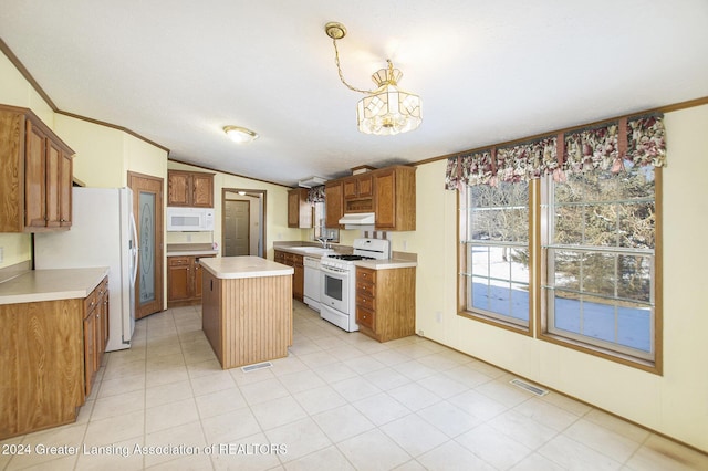 kitchen with pendant lighting, white appliances, a kitchen island, vaulted ceiling, and a chandelier