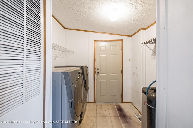 laundry room with a textured ceiling, ornamental molding, and washing machine and clothes dryer