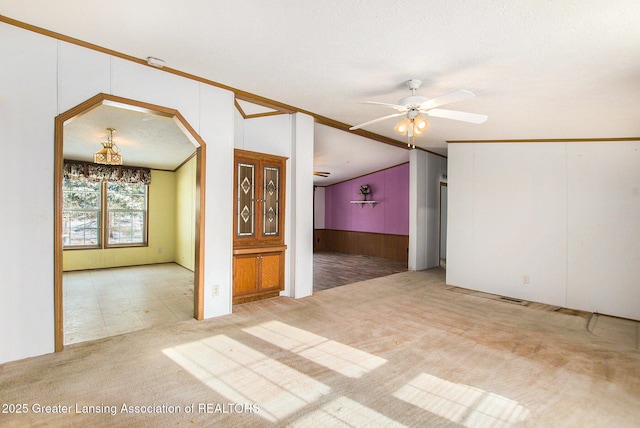 empty room with ceiling fan, light carpet, and wood walls